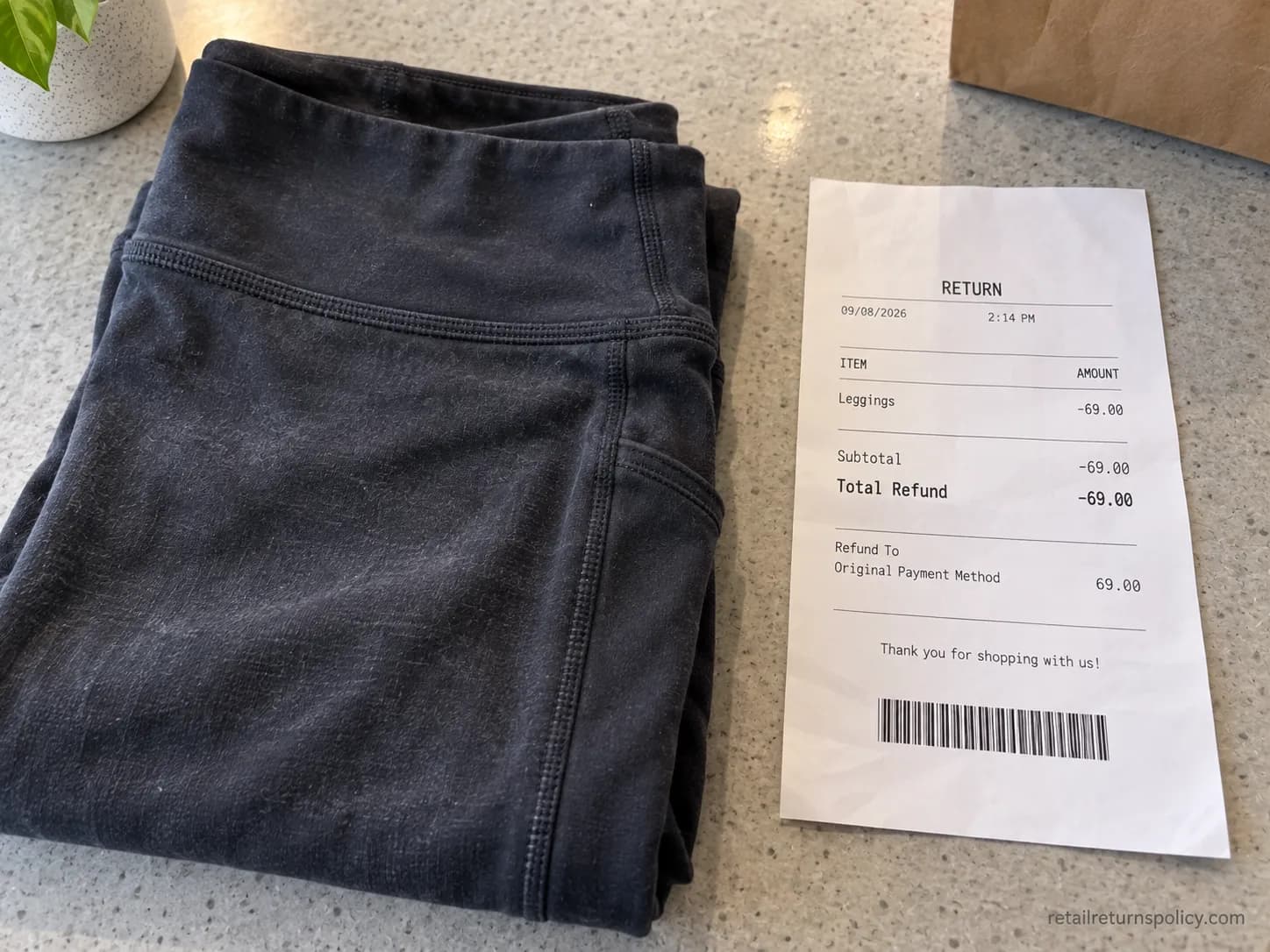 Worn washed Athleta leggings beside an accepted return slip under the Give-It-A-Workout Guarantee.