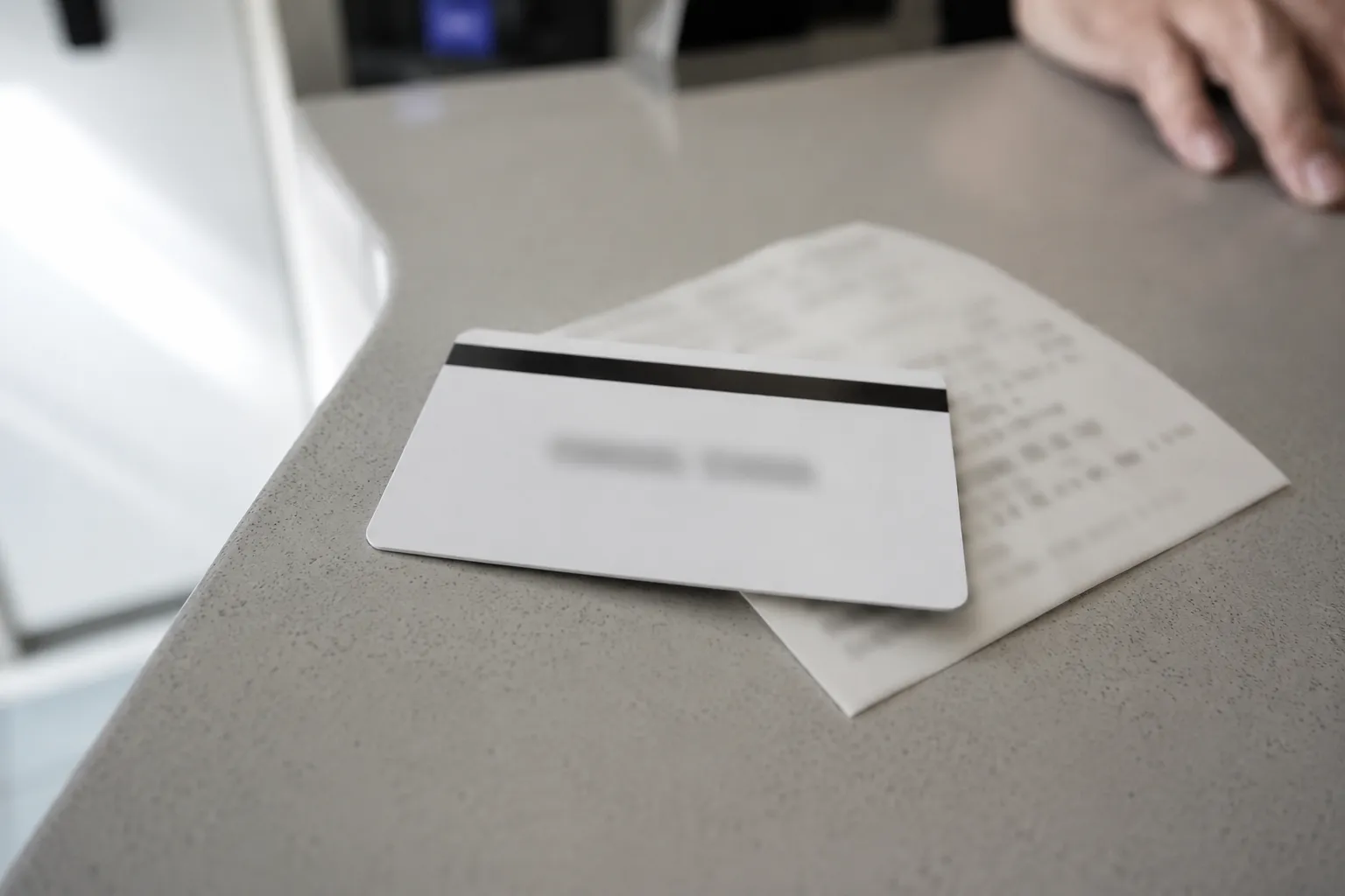 Merchandise return card issued after a no-receipt return resting on a guest services counter with a blurred receipt underneath and card details obscured for privacy.