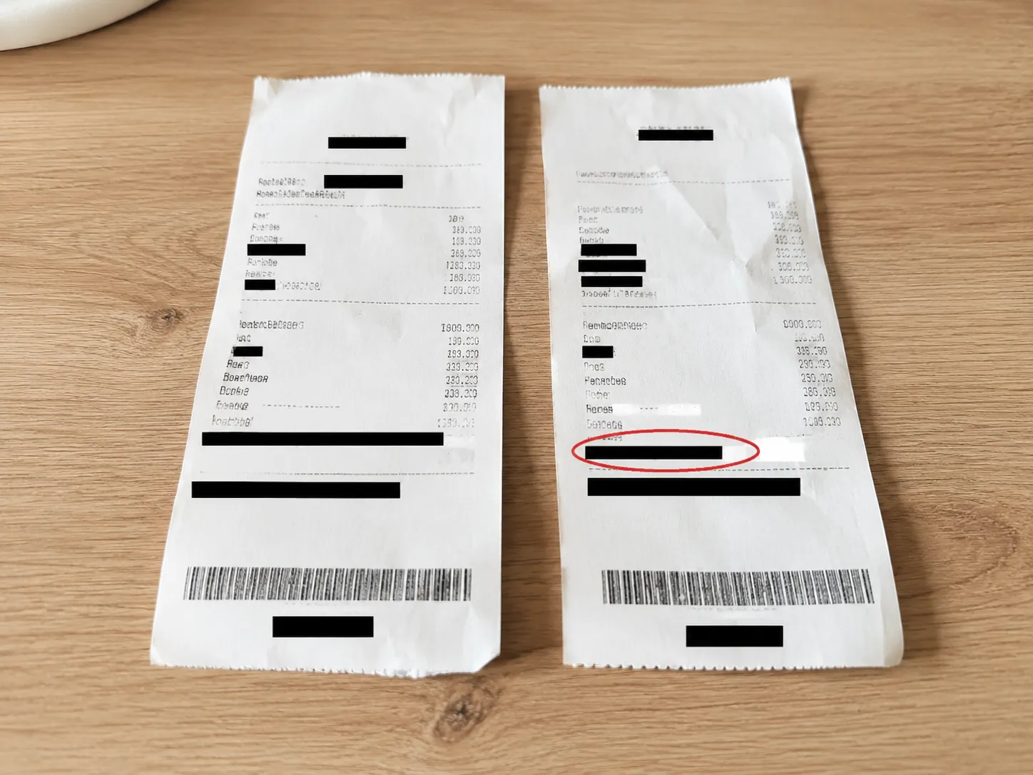 Two redacted store receipts lie side by side on a light wooden table. The denied-return receipt on the right has its transaction ID area circled in red, illustrating a rejected return record.