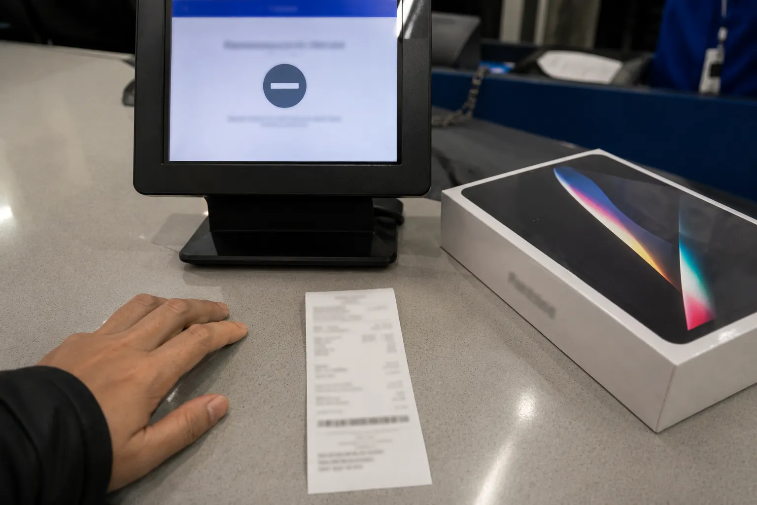 Point-of-sale screen displaying a return decline notice beside a return slip and boxed electronics item during an over-cap return attempt, with all sensitive details blurred.