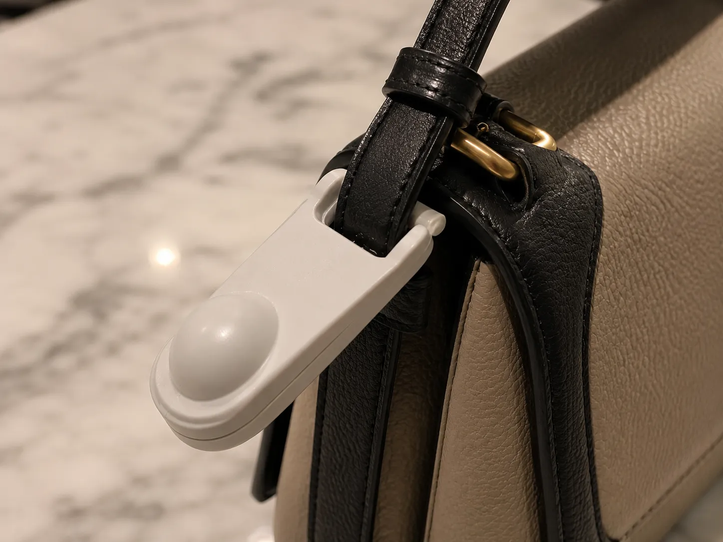 Large plastic security b-tag still attached to a designer handbag before a Neiman Marcus return