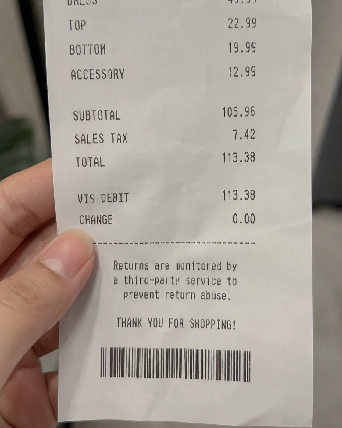 Close-up of a retail receipt held in one hand, showing a printed notice that returns are tracked by a third-party service, with soft lighting and a blurred background. Representative illustration.