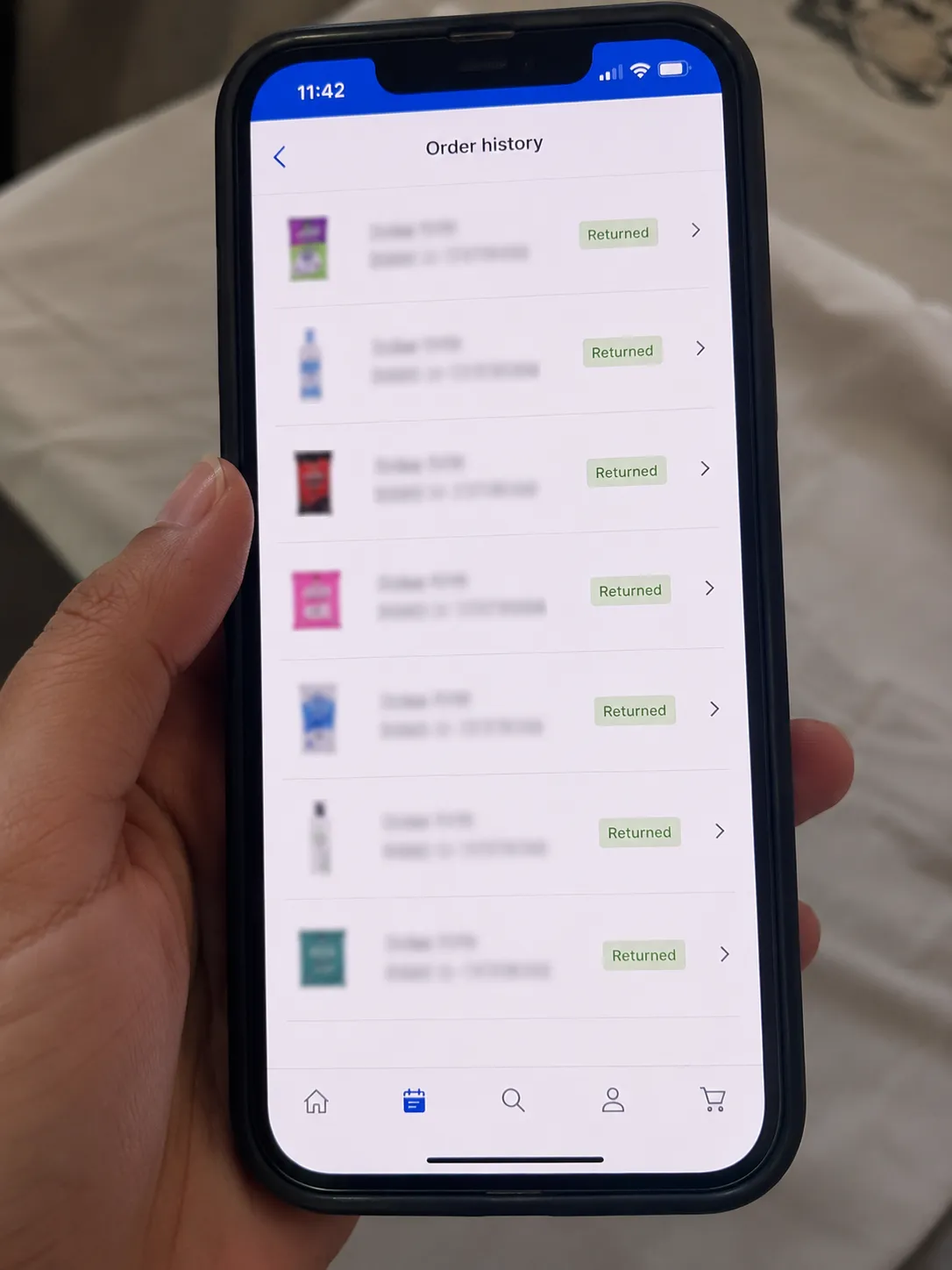 Phone displaying an order history with multiple accepted returns marked “Returned,” while customer names and order numbers are blurred to protect privacy.