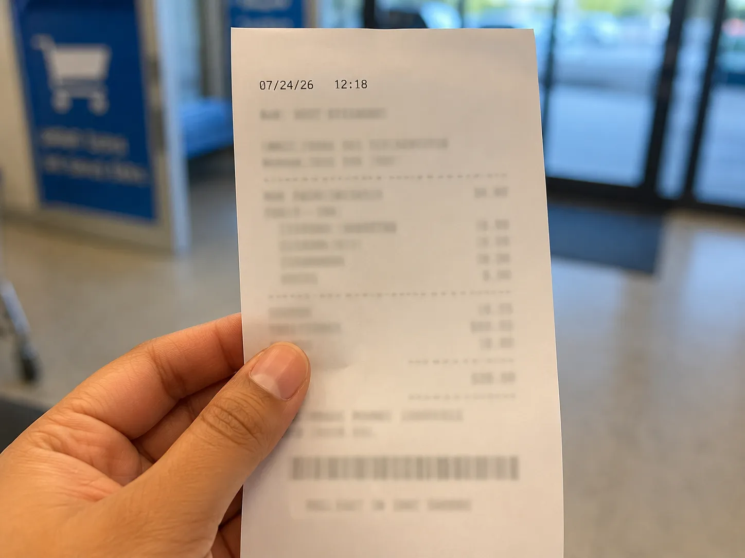 Representative illustration of a dated retail receipt held in front of a blurred store exit, showing a successful in-store purchase after an online account restriction, with personal details redacted.