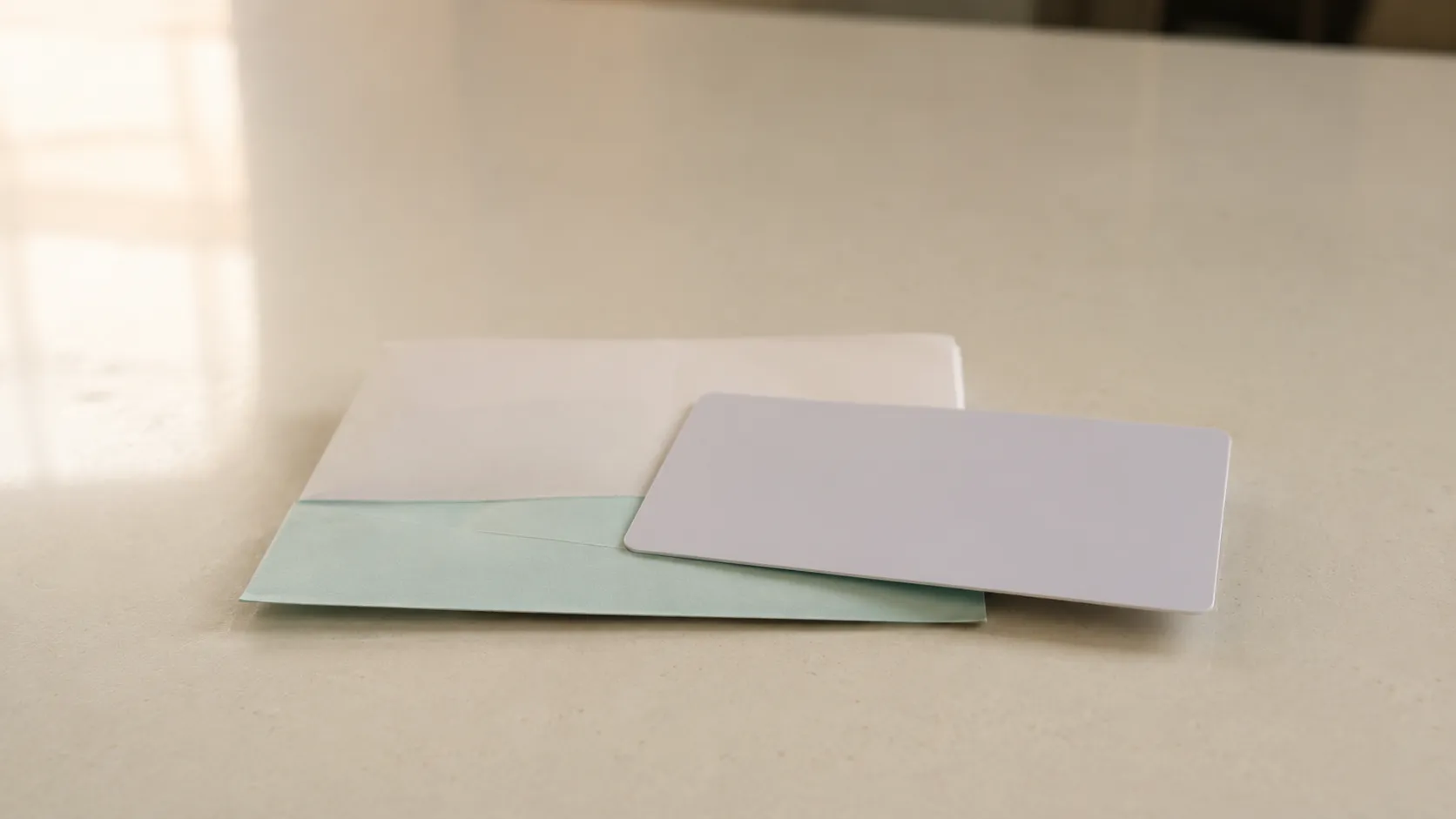 Representative illustration of a blank unbranded store credit card resting on a folded return slip on a cream-colored counter, depicting a no-receipt gift return experience and store credit payout.
